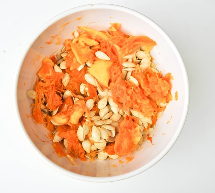 Uncooked pumpkin seeds with pumpkin "guts."